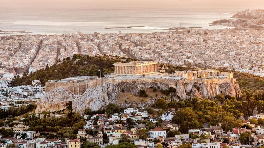 Athens spreading to the sea around the Acropolis at sunset seen on an Athens airport transfer