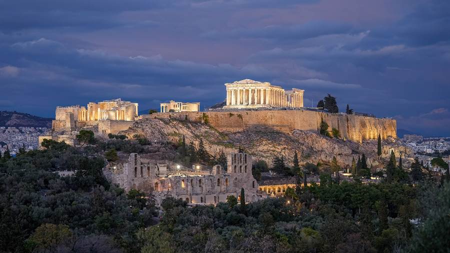 The Acropolis of Athens lit at dusk above the Odeon of Herodes Atticus, a highlight of Athens tours