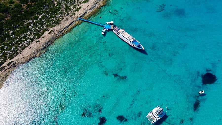 A cruise boat in clear turquoise water on the route of a Balos lagoon cruise
