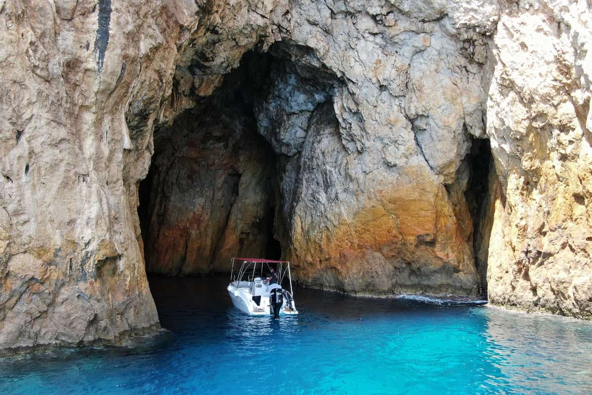 A small boat at the mouth of a sea cave near Paleokastritsa on a Corfu boat trip