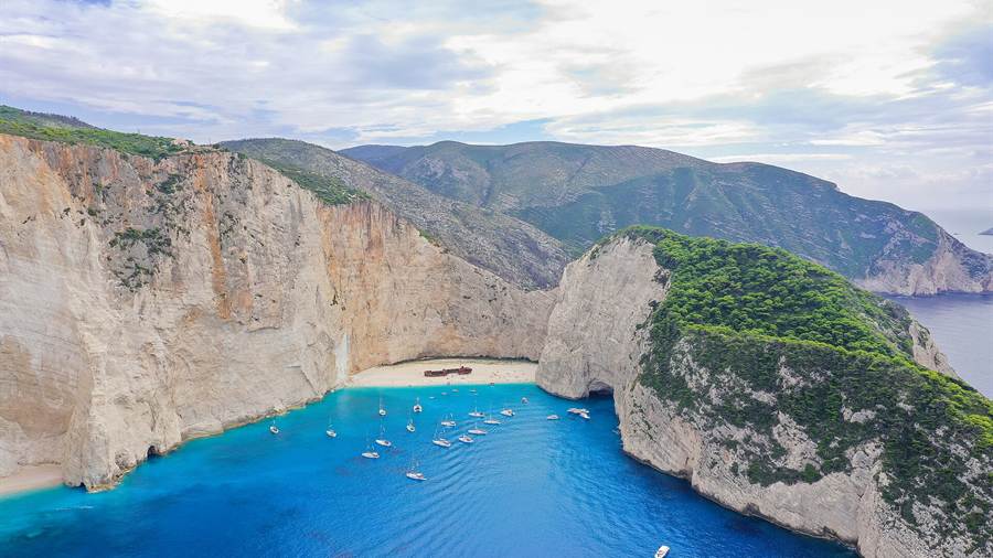 Aerial view of Navagio Shipwreck Beach on Zakynthos with white cliffs and boats