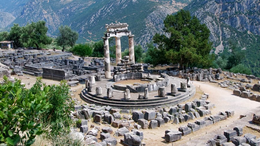 The round Tholos in the sanctuary of Athena Pronaia at Delphi below the cliffs, seen on a Delphi Meteora tour
