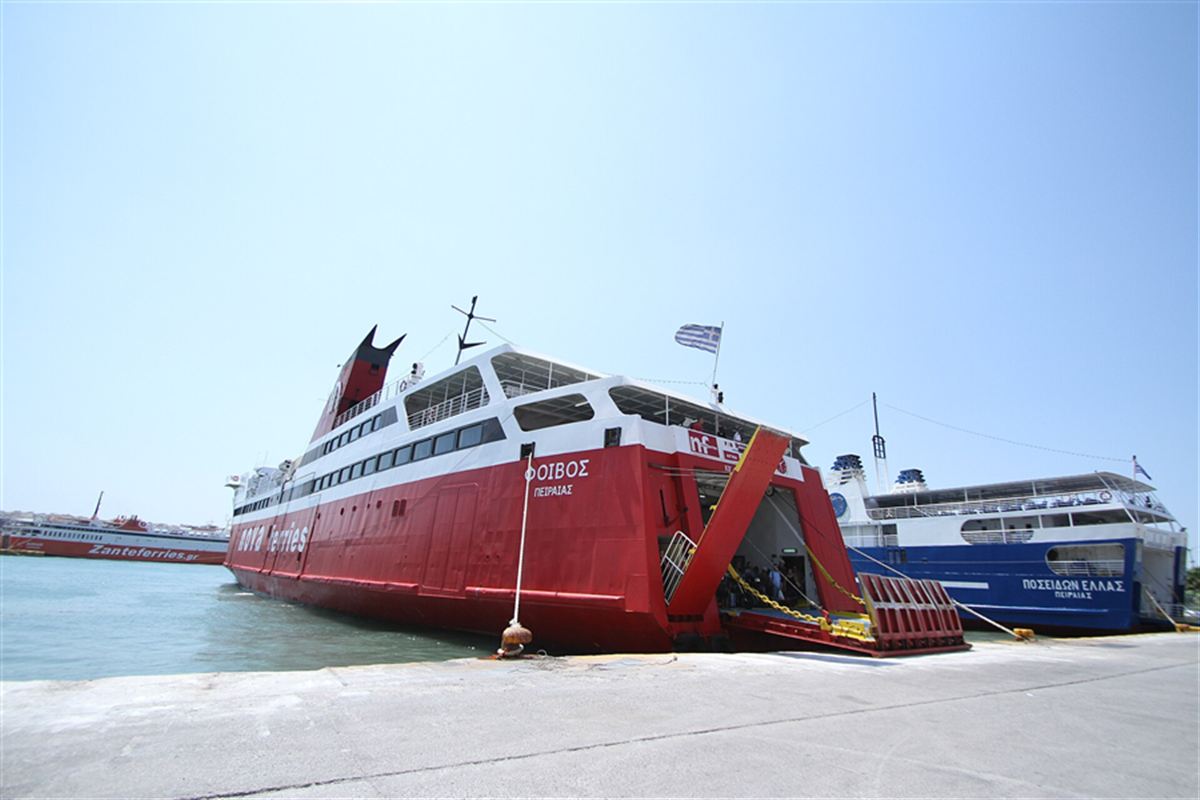 Red ferry with open ramp moored at the quay in Piraeus port