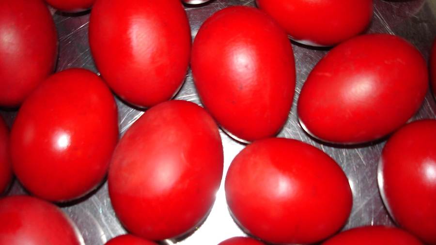 Bright red dyed Easter eggs packed together in a metal tray