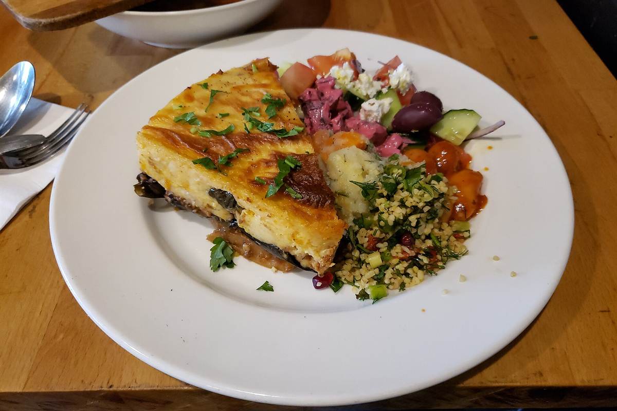 A plate of moussaka with salad and olives in a Greek taverna