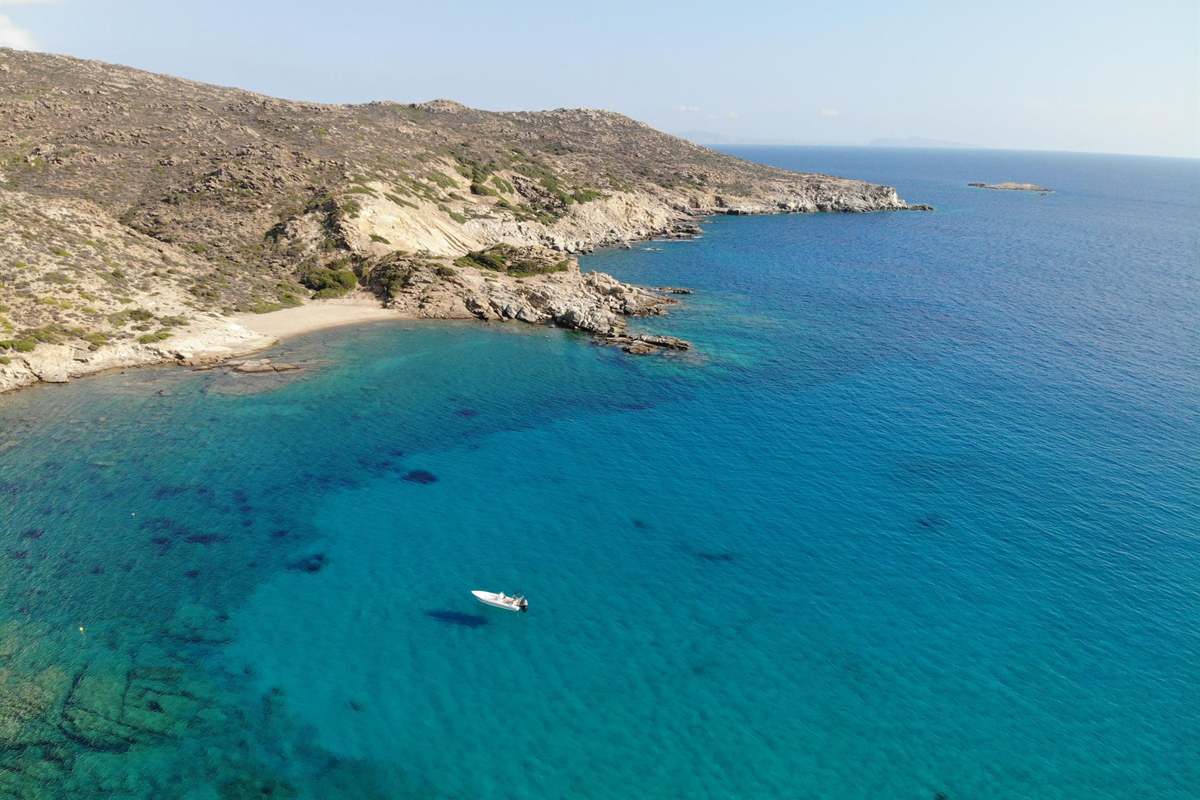 A rocky headland and clear blue water on the coast of Ios, the setting of an Ios boat trip