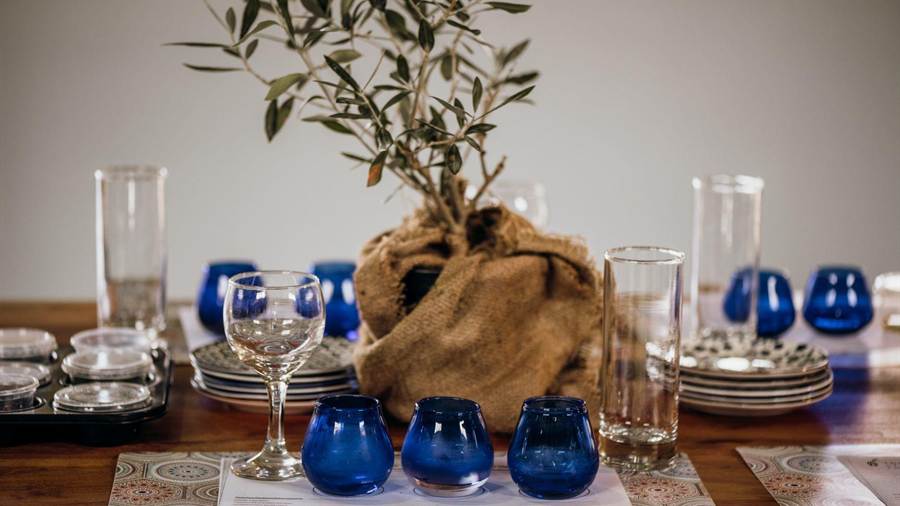 Glasses and blue tasting cups set on a table for an olive oil tasting, a stop on a Kalamata food tour