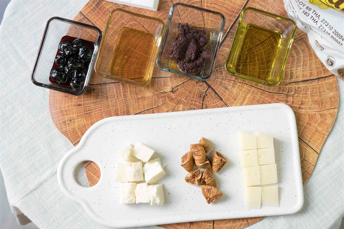 A tasting board of olives, honey, olive oil and cheese, the kind of plate served on a Kalamata food tour