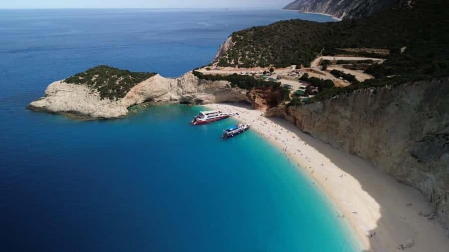 Two tour boats nose onto the white beach below tall cliffs at Porto Katsiki on a Lefkada boat tour