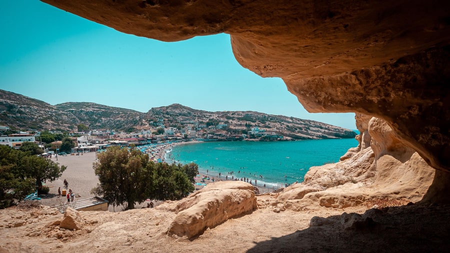 View of Matala bay and village through a cave opening on the cliff, seen on a Matala tour