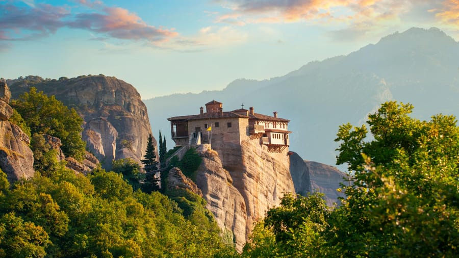 Roussanou monastery on its rock above green trees, a stop on a Meteora day trip from Athens