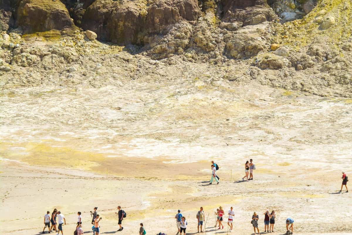 Visitors walk across the pale sulphur-streaked floor of the Stefanos crater on a Nisyros volcano tour