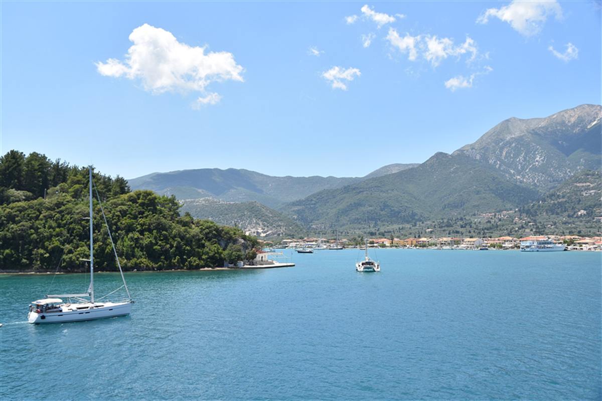 Sailing boat on the blue water of Nydri Bay with Lefkada mountains behind, Nydri boat cruise