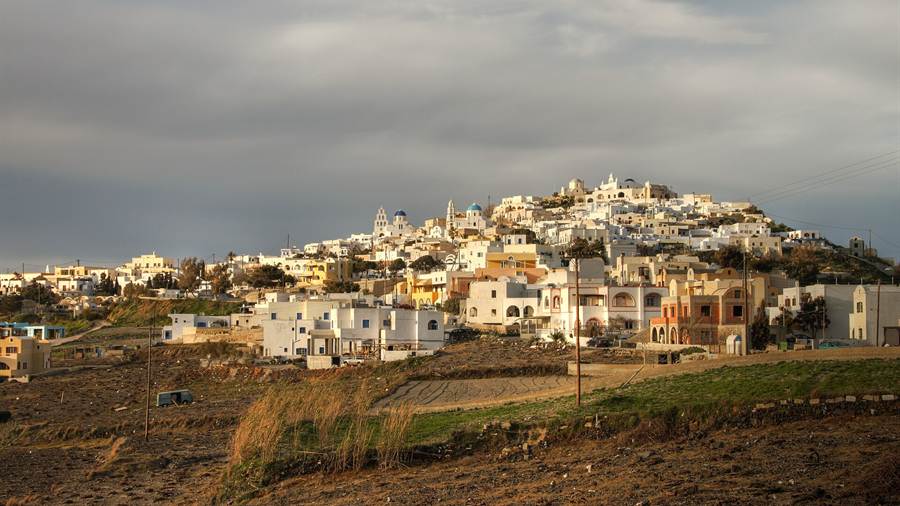 Pyrgos village climbing a hill on Santorini under a cloudy sky