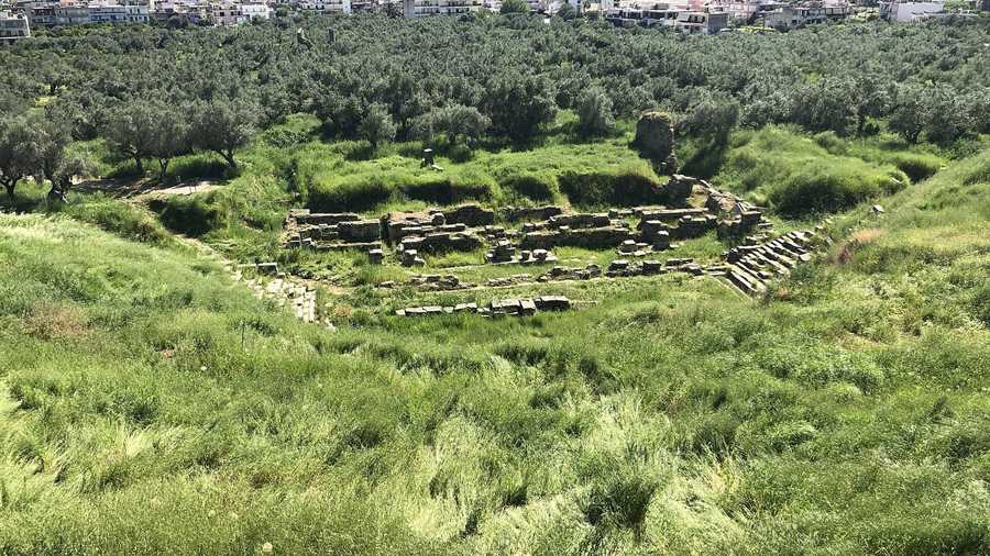 Green hollow with the ancient theatre site of Sparta and the town beyond
