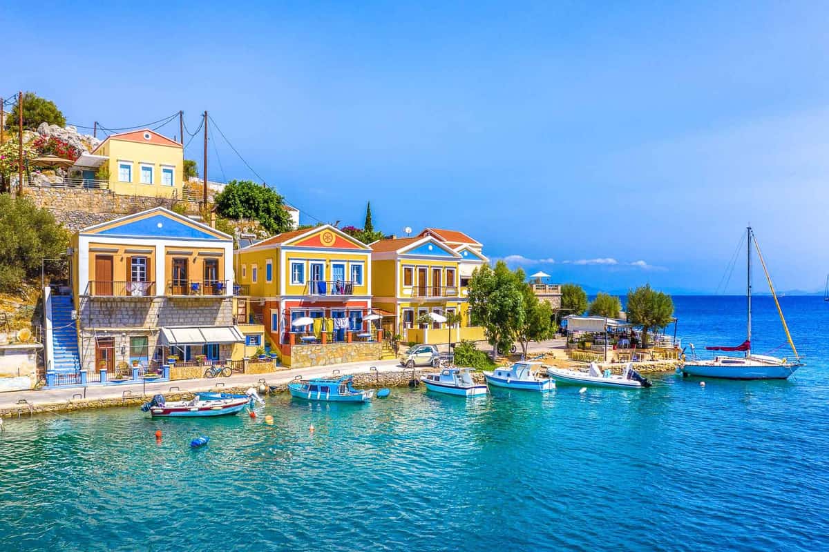 Colourful mansions and small boats in the harbour of Symi, the goal of a Symi day trip from Rhodes