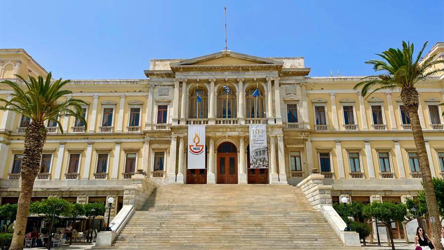 The neoclassical town hall of Ermoupoli with palm trees in front, a stop on a Syros day trip