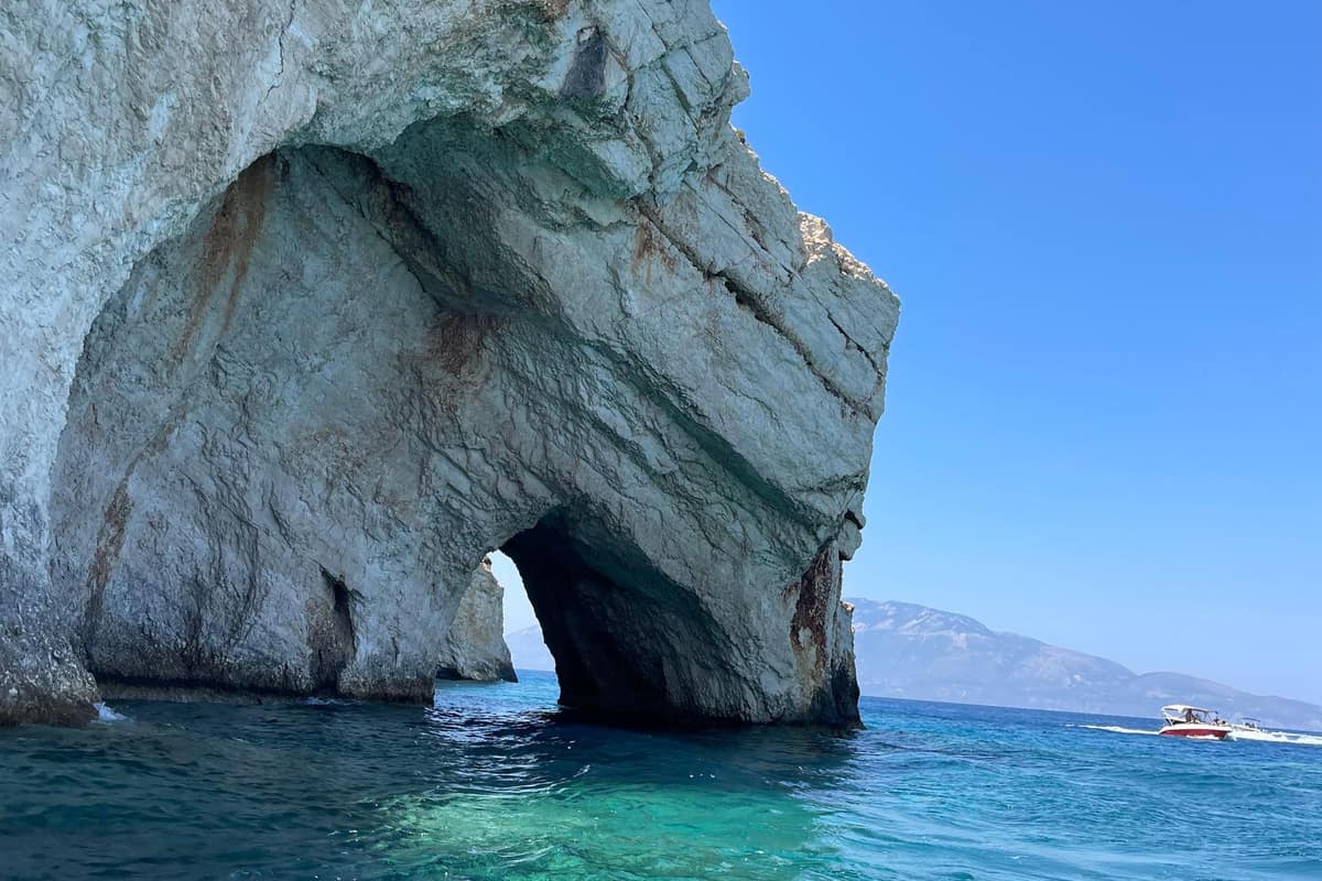 A white limestone arch over clear blue water at the Zakynthos blue caves